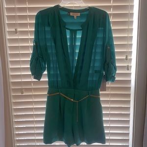 Sheer top romper; shorts not see through; decorative gold belt included.